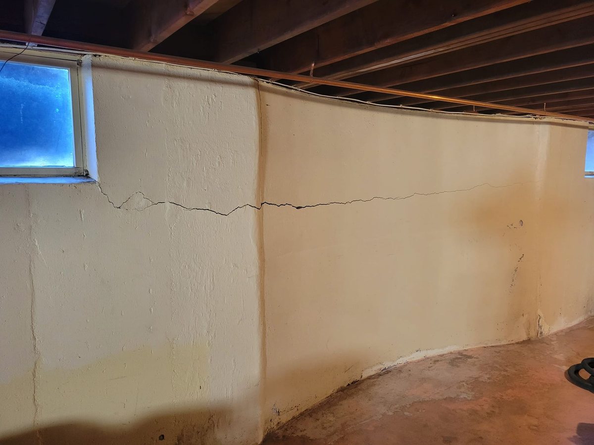 The same basement wall with a long horizontal crack, before repair